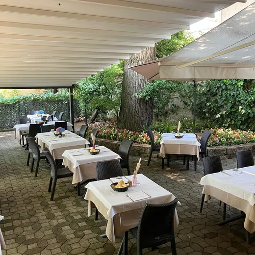 Il porticato tra l'edera e gli alberi del giardino